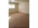 Living room features neutral carpet and white walls illuminated by a window at 7990 Firethorn, Las Vegas, NV 89123