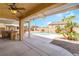 Covered patio with grill area overlooks a pool and lush landscaping at 824 Bussora Rose Dr, Henderson, NV 89015