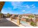 Scenic balcony view of a community pool, lush landscaping, and neighborhood homes under a bright sky at 824 Bussora Rose Dr, Henderson, NV 89015