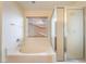 Well-lit bathroom featuring a soaking tub with tile surround and a glass-enclosed shower at 824 Bussora Rose Dr, Henderson, NV 89015