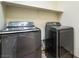 Modern laundry room with sleek washer and dryer units and overhead shelf at 824 Bussora Rose Dr, Henderson, NV 89015