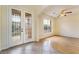 Bright living room featuring wood floors, ceiling fan, and elegant glass paneled front doors at 824 Bussora Rose Dr, Henderson, NV 89015