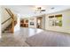 Open-concept space with tiled flooring, staircase, access to the kitchen, and sliding door to backyard at 824 Bussora Rose Dr, Henderson, NV 89015