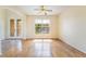 Bright room featuring wood floors, ceiling fan, elegant glass paneled front doors, and large windows at 824 Bussora Rose Dr, Henderson, NV 89015