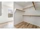 Bright walk-in closet with wood shelving and ample storage space, complemented by modern wood flooring at 824 Bussora Rose Dr, Henderson, NV 89015