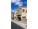 Attractive townhome featuring tan stucco, a balcony, a garage, and stone accents at 8664 Traveling Breeze Ave # 102, Las Vegas, NV 89178