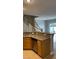 Kitchen area features oak cabinets, stainless steel dishwasher, and overlooks open floorplan and staircase at 8664 Traveling Breeze Ave # 102, Las Vegas, NV 89178