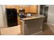 Well-lit kitchen features stainless steel appliances, wooden cabinetry, and a convenient breakfast bar at 8664 Traveling Breeze Ave # 102, Las Vegas, NV 89178
