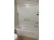 Bathroom shower featuring a full tub, white tile, and shelving at 8664 Traveling Breeze Ave # 102, Las Vegas, NV 89178