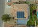 View of a tile roof with solar panels, patio, and backyard with mature trees and lush greenery at 8980 Tumbling Pebble Way, Las Vegas, NV 89123
