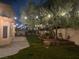 A spacious backyard with a large tree decorated with string lights and a stamped concrete patio at 8980 Tumbling Pebble Way, Las Vegas, NV 89123