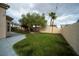 Large backyard showcasing a lush green lawn, trees, and a stamped concrete patio at 8980 Tumbling Pebble Way, Las Vegas, NV 89123
