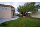 Backyard view highlighting the lush green lawn, complemented by the well-placed mature trees, and manicured privacy landscaping at 8980 Tumbling Pebble Way, Las Vegas, NV 89123