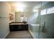 Bathroom features dark cabinets, granite countertops, glass shower with modern tub at 8980 Tumbling Pebble Way, Las Vegas, NV 89123