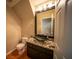 Half-bathroom with granite countertop, modern vessel sink, and wood floor at 8980 Tumbling Pebble Way, Las Vegas, NV 89123