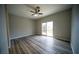 Spacious bedroom featuring wood floors, a ceiling fan, and sliding glass doors to the backyard at 8980 Tumbling Pebble Way, Las Vegas, NV 89123
