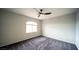 A comfortable bedroom with neutral walls, soft gray carpet, and an arched window, offering a cozy and inviting atmosphere at 8980 Tumbling Pebble Way, Las Vegas, NV 89123