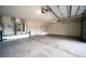 Spacious garage featuring concrete flooring, installed air-conditioning unit, and a door to interior of house at 8980 Tumbling Pebble Way, Las Vegas, NV 89123