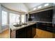 Modern kitchen with dark cabinets, granite countertops, a central island, and stainless steel appliances, a chef's dream at 8980 Tumbling Pebble Way, Las Vegas, NV 89123