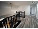 Hallway with wood flooring, black railings, and bright lighting at 8980 Tumbling Pebble Way, Las Vegas, NV 89123