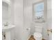 Powder room featuring a pedestal sink, toilet, and window at 9049 Teetering Rock Ave, Las Vegas, NV 89143