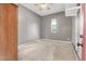 A gray bedroom featuring carpeted floors, a window, a small closet, and a ceiling fan at 9049 Teetering Rock Ave, Las Vegas, NV 89143