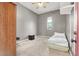This gray bedroom has carpeted floors, a window, a ceiling fan, and a small bed on the floor at 9049 Teetering Rock Ave, Las Vegas, NV 89143