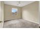 Well-lit bedroom with a ceiling fan, plush carpet, and a large window providing natural light and neighborhood views at 9049 Teetering Rock Ave, Las Vegas, NV 89143