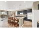 Well-lit kitchen featuring granite countertops, black cabinets, stainless steel appliances, an island, and adjacent dining area at 9049 Teetering Rock Ave, Las Vegas, NV 89143