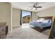 Comfortable main bedroom featuring a ceiling fan and access to a private balcony for relaxation and outdoor enjoyment at 9049 Teetering Rock Ave, Las Vegas, NV 89143