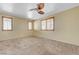 Bedroom with neutral carpet and walls, ceiling fan, and shuttered windows providing ample natural light at 9073 Spoonbill Ridge Pl, Las Vegas, NV 89143
