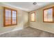 Empty bedroom featuring three large windows with wooden shutters and neutral paint at 9073 Spoonbill Ridge Pl, Las Vegas, NV 89143