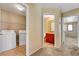 Hallway view including laundry room and bathroom with neutral-toned walls and tile flooring at 9073 Spoonbill Ridge Pl, Las Vegas, NV 89143