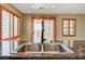 Granite countertop featuring a stainless steel undermount sink and modern faucet, complemented by natural light from shuttered windows at 9073 Spoonbill Ridge Pl, Las Vegas, NV 89143