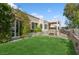 Charming backyard showcasing lush green grass, mature landscaping, and a spa with cover at 9211 Golden Feather Ct, Las Vegas, NV 89147