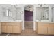 Bright bathroom featuring double sinks, tile flooring, and an arched doorway leading to a bedroom at 9211 Golden Feather Ct, Las Vegas, NV 89147