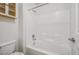 Clean bathroom featuring a white tiled shower-tub and a bright white toilet at 9211 Golden Feather Ct, Las Vegas, NV 89147