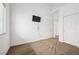 This bedroom has neutral walls, a mounted television and carpeted floors at 9211 Golden Feather Ct, Las Vegas, NV 89147