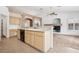 Bright kitchen featuring tile backsplash, countertop seating, and direct access to living room at 9211 Golden Feather Ct, Las Vegas, NV 89147