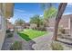 The backyard has an outdoor kitchen with artificial grass and desert landscaping at 9221 Steeltree St, Las Vegas, NV 89143