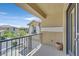 Cozy balcony with black metal railing, tan stucco, and view of surrounding homes and blue sky at 9221 Steeltree St, Las Vegas, NV 89143