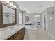 Bathroom showcasing dual sinks, tiled tub, glass block window, and neutral color palette at 9221 Steeltree St, Las Vegas, NV 89143