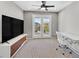 Bright bedroom features a desk, chair, media center, and french doors to a balcony at 9221 Steeltree St, Las Vegas, NV 89143