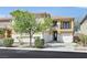Two-story home featuring a charming balcony, desert landscaping, and a two-car garage with an inviting curb appeal at 9221 Steeltree St, Las Vegas, NV 89143
