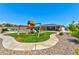A backyard with grassy area, playset, and desert landscaping surrounding the yard's perimeter at 9511 Star Vista Ct, Las Vegas, NV 89149