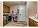 A modern laundry room boasts stainless steel appliances, wood cabinets, and ample storage for household chores at 9511 Star Vista Ct, Las Vegas, NV 89149