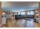 Spacious living area with hardwood floors, a large sectional sofa, and an adjacent kitchen area at 9511 Star Vista Ct, Las Vegas, NV 89149