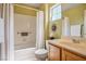 Bright bathroom featuring a shower-tub combo, a wood vanity, and decorative wall art at 9536 Ruby Hills Dr, Las Vegas, NV 89134