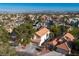 An aerial shot focuses on a Southwestern-style property with mature trees, tile roof, and desert landscaping at 1100 Meridian Bay Dr, Las Vegas, NV 89128
