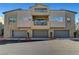Modern townhome complex featuring three-car garages, balconies, and neutral exterior paint at 11297 Essence Point Ave # 102, Las Vegas, NV 89135
